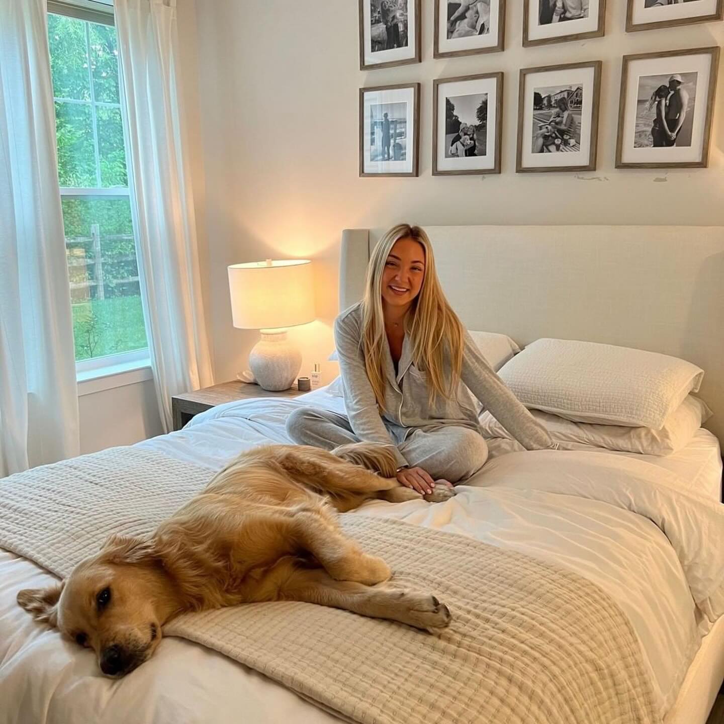 Happy woman lying on her new bed with her golden retriever. Mattress On Demand has a bed for everyone.